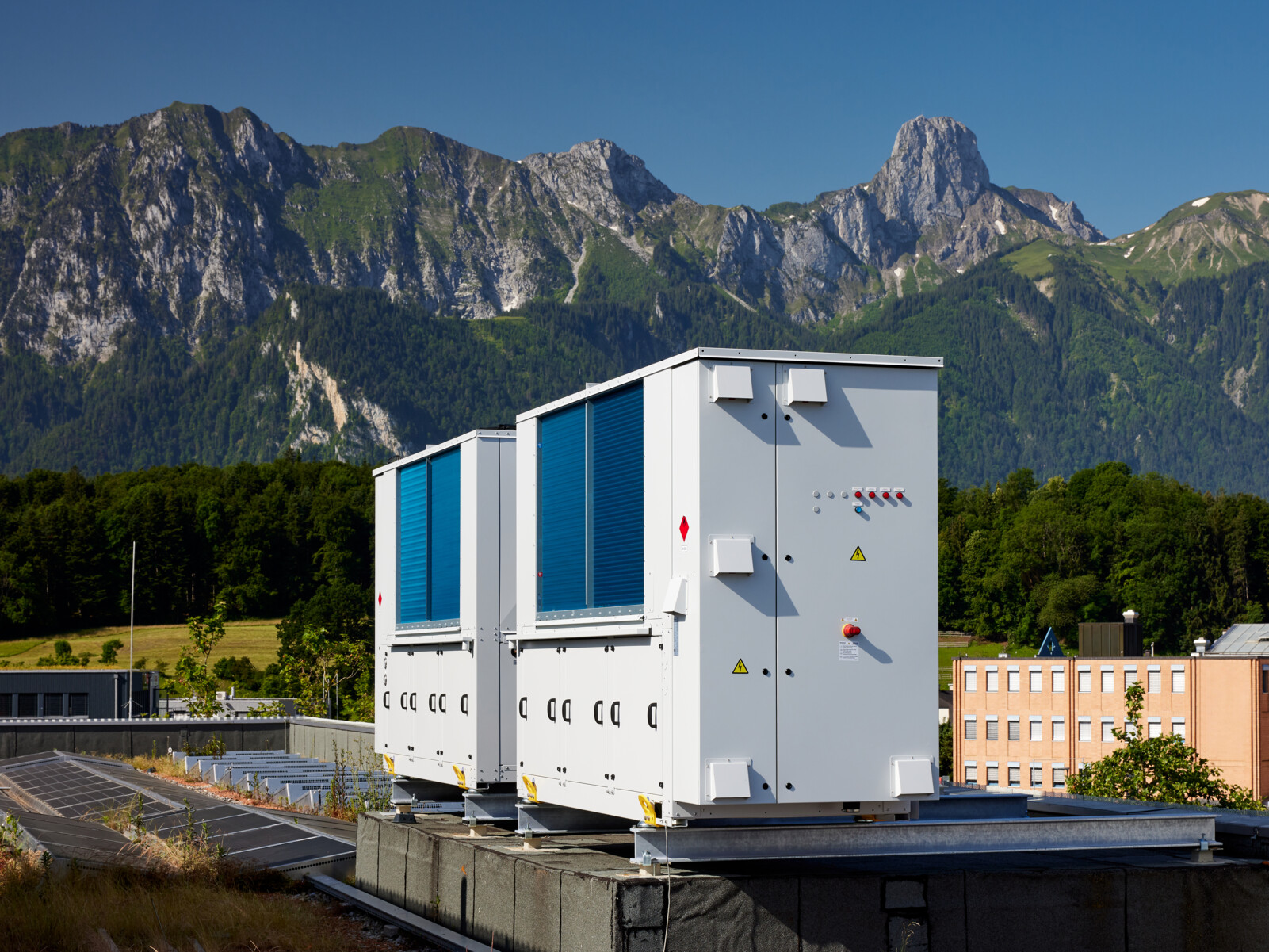 Nachhaltige Wärmepumpe von Zaugg AG auf einem Dach vor einer malerischen Berglandschaft – Energieeffiziente Heiz- und Kühllösungen.