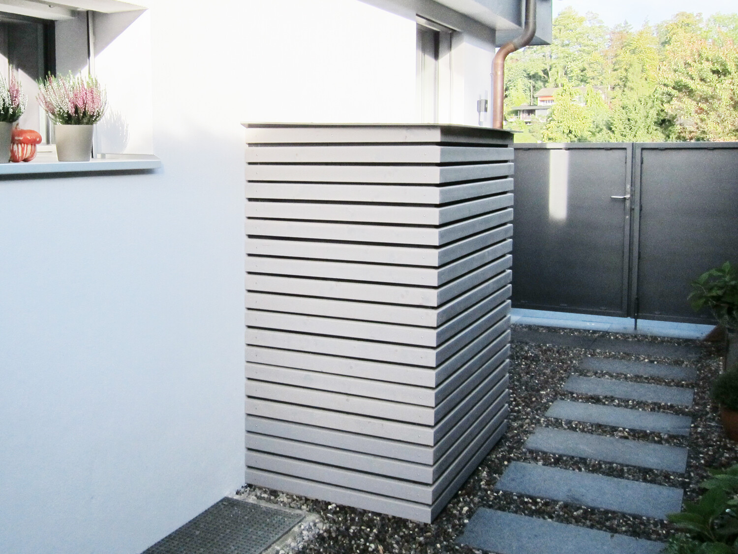 Schalldämmgehäuse einer Klimaaussenanlage, aussen an einem Wohnhaus. Das Schallschutzgehäuse reduziert den Lärm der Anlage und sorgt für eine geräuscharme Umgebung.